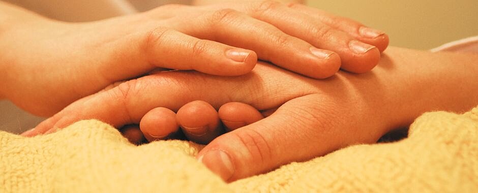 Bild: Pixabay Nahaufnahme: Eine Hand hält die Hand einer pflegbedürftigen Person