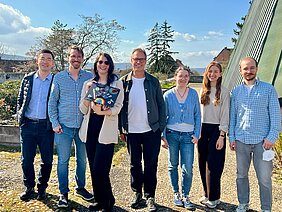 Die sieben Mitarbeiterinnen und Mitarbeiter der AG stehen draußen, die dritte von links ist Felicitas Schlott mit einem gebastelten Doktorhut in der Hand 