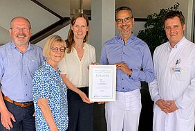Delegation der DCIG und der von der Gesellschaft herausgegebenen Fachzeitschrift „Schnecke – Leben mit Cochlea-Implantat & Hörgerät“ das UKW und überbrachte eine Urkunde.