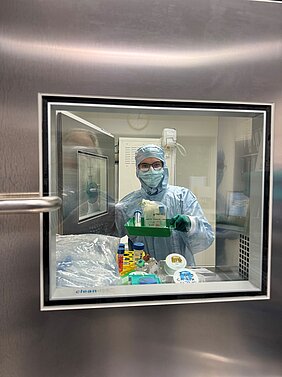 Die TA in kompletter Reinraum-Montur vor der Schranke. 