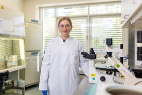 Eine Medizinische Technologin für Laboratoriumsanalytik steht in einem Labor 