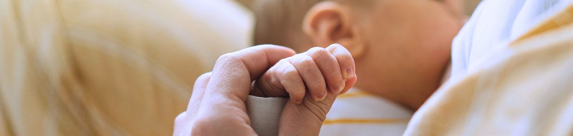 Stillberatung und Stillambulanz © Анастасія Стягайло- stock.adobe.com Baby hält beim Stillen die Hand der Mutter