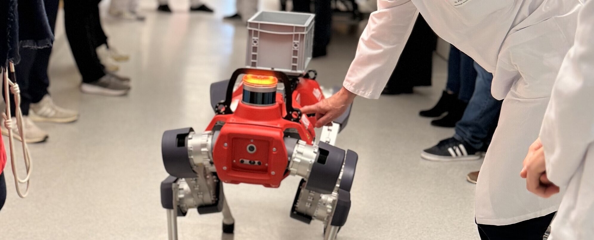 Roboterhund HELIA wird von Professor Matthias Goebeler getätschelt.