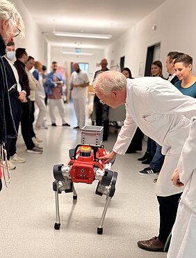 Roboterhund HELIA wird von Professor Matthias Goebeler getätschelt. 