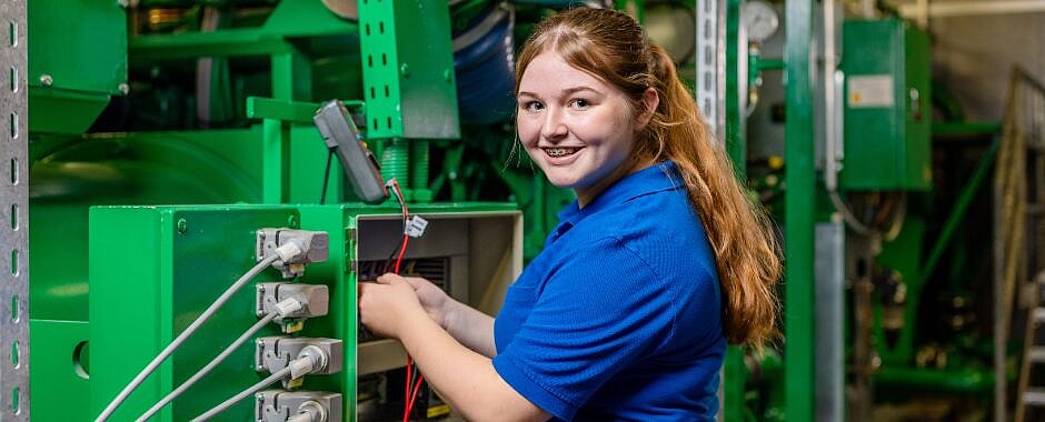 Zu den Zu den Ausbildungen im Bereich Elektronik, Tierpflege Symbolbild: Azubine am Schaltkasten einer großen Betriebsanlage