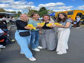 4 Azubis mit Burger vom Food-Truck bei Azubi-Welcome-Party
