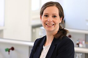 Porträt von Stefanie Kampmeier, die Professorin trägt die dunklen Haare im Pferdeschwanz, einen blauen Blazer und weißes T-Shirt
