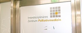 Tür des Zentrums für Palliativmedizin mit Aufschrift und Logo