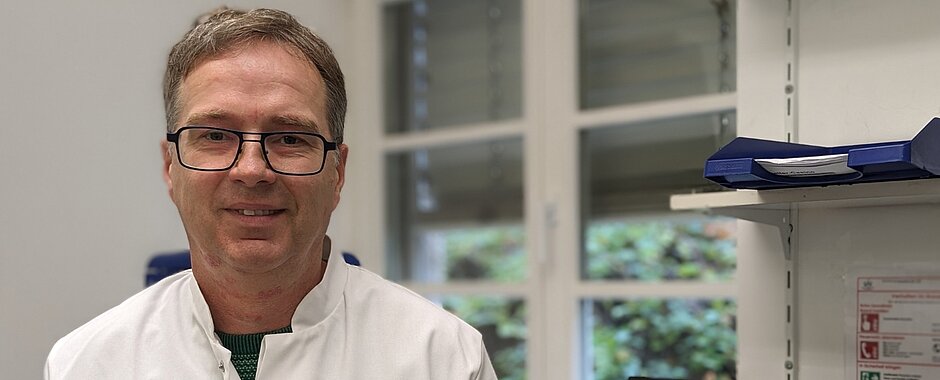 Marc Schmidt steht in einem weißen Kittel in seinem Büro 