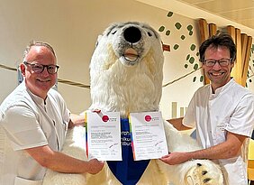 Prof. Dr. Thomas Meyer und Prof. Dr. Christoph Härtel freuen sich über das erneut verliehene Gütesiegel „Ausgezeichnet. Für Kinder“.