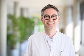 Porträt von Alexander Hann im weißen Kittel in der Magistrale des ZIM