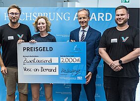 Die Gewinner und Preisverleiher posieren mit überdimensional großem Scheck über 2.000 Euro 