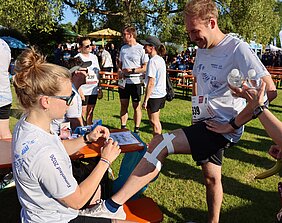 Die Physiotherapeutinnen und Physiotherapeuten des UKW bereiteten die Teilnehmenden mit professionellem Taping und einem gemeinsamen Aufwärmprogramm auf den Start vor. © Kim Sammet / UKW