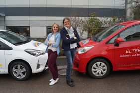 Die beiden ambulanten Schwestern Barbara Cebertowicz (links) und Angela Hanebuth (rechts) vor ihren Fahrzeugen.