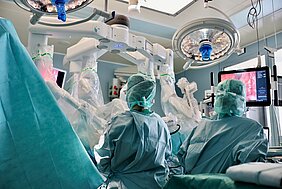 Blick in den OP auf das OP-Team, das sich um den OP-Tisch reiht. 