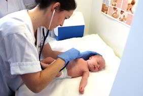 Fabian, das 200ste MIAI-Baby wird von der Studienärztin mit dem Stethoskop abhört. 