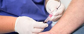 Eine Schwester nimmt einem Patienten Blut ab.