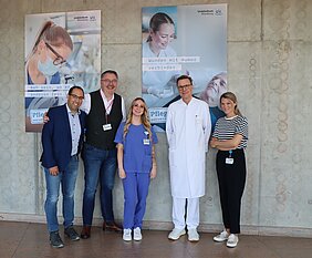 Stefan Rehberger, Projektleiter und Klinikpflegedienstleitung, UKW-Pflegedirektor Marcus Huppertz, Cindy Glanert aus der UKW-Pflege, Prof. Dr. Christoph-Thomas Germer (Klinikdirektor Chirurgie I) und Lena Ossiander, Leiterin der Stabsstelle Marketing (v.l.) beim Start der Ausstellung „Pflege, weil ich´s kann.“ Foto: UKW / Kim Sammet