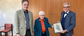 Foto zeigt Professor Michael Stolberg (links), Leiter des Instituts für Geschichte der Medizin, und Professor Matthias Frosch, Dekan der Medizinischen Fakultät, mit der Urenkelin Albert von Köllikers.