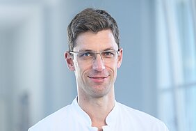 Porträtbild von Patrick Meybohm in weißem Kittel