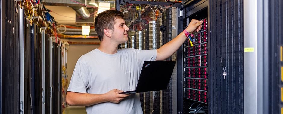 zur Ausbildung im Bereich Fachinformatik Symbolbild: Azubi mit Laptop im Serverraum