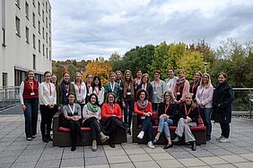 Die Teilnehmerinnen posieren draußen auf einer Hotelterrasse fürs Bild - vorne sitzen sechs Frauen auf zwei Sofas, dahinter gruppieren sich die anderen Frauen. 