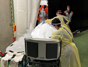 Nach der erfolgreichen Dekontamination übernehmen speziell geschulte Pflegekräfte des UKW den Patienten. Er wird dabei schnell mit Handtüchern abgedeckt. Foto: UKW/Dreising