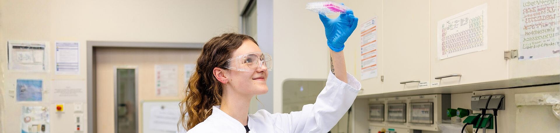 Azubi Medizinische Technologie Laboratoriumsanalytik (MTL). Foto: Salih Usta, KI-generativ erweitert Symbolbild: Azubine hält eine Laborprobe hoch