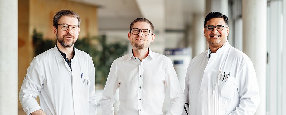 Bild drei Wissenschaftler im weißen Kittel im Gang vom Zentrum für innere und operative Medizin 