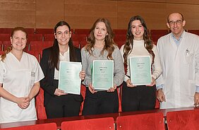 In der Mitte die drei Preisträgerinnen Medi Biberova, Nina Stützel und Sophie Bruchmann (von links), umrahmt von Dr. Julia Ludwig und Prof. Dr. Gabriel Krastl vom Zentrum für Zahn-, Mund- und Kiefergesundheit des Uniklinikums Würzburg. Foto: UKW