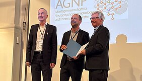 Vertreter der DGBP und Preisträger stehen auf der Bühne und lächeln für die Fotografen 