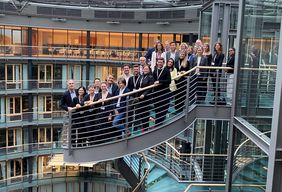 Vertreter des Projekts positionieren sich in Berlin auf einer Wendeltreppe 