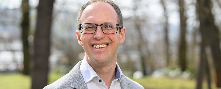 Alexander Soutschek steht im Garten des Zentrums für Psychische Gesundheit 