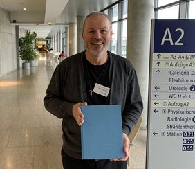 Pater Maximilian Bauer präsentiert eines der im Raum der Stille am UKW ausliegenden Anliegenbücher – eines der seelsorgerischen Angebote, die ihm besonders am Herzen liegen.