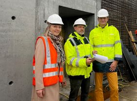 Grit Liebau, Leiterin des Bereichs Universitätsbau des Staatlichen Bauamtes Würzburg, Dominik Daß (Arge wörner traxler richter / Wenzel + Wenzel) und UKW-Vorstand Prof. Dr. Jens Maschmann im Gespräch auf der Baustelle.