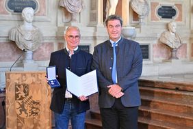 Ministerpräsident Söder und Dr. Schwarzmann mit Urkunde und Christophorus-Medaille