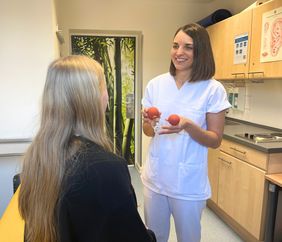 Antonia Weimann (Pflegefachkraft am UKW) berät im Rahmen der naturheilkundlichen Pflegesprechstunde eine Krebspatientin zum Thema Schröpfen.