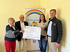Mitarbeitende der Mercedes-Benz-Betriebe übergeben einen symbolischen Spendencheck an die Elterninitiative Regenbogen