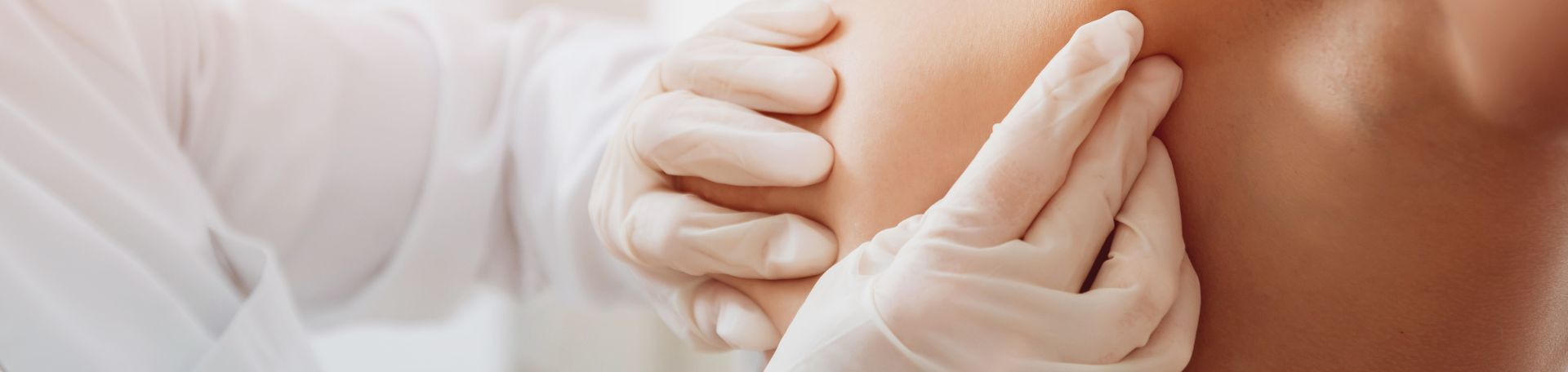 Untersuchung: eine nackte Brust, die medizinisch abgetastet wird