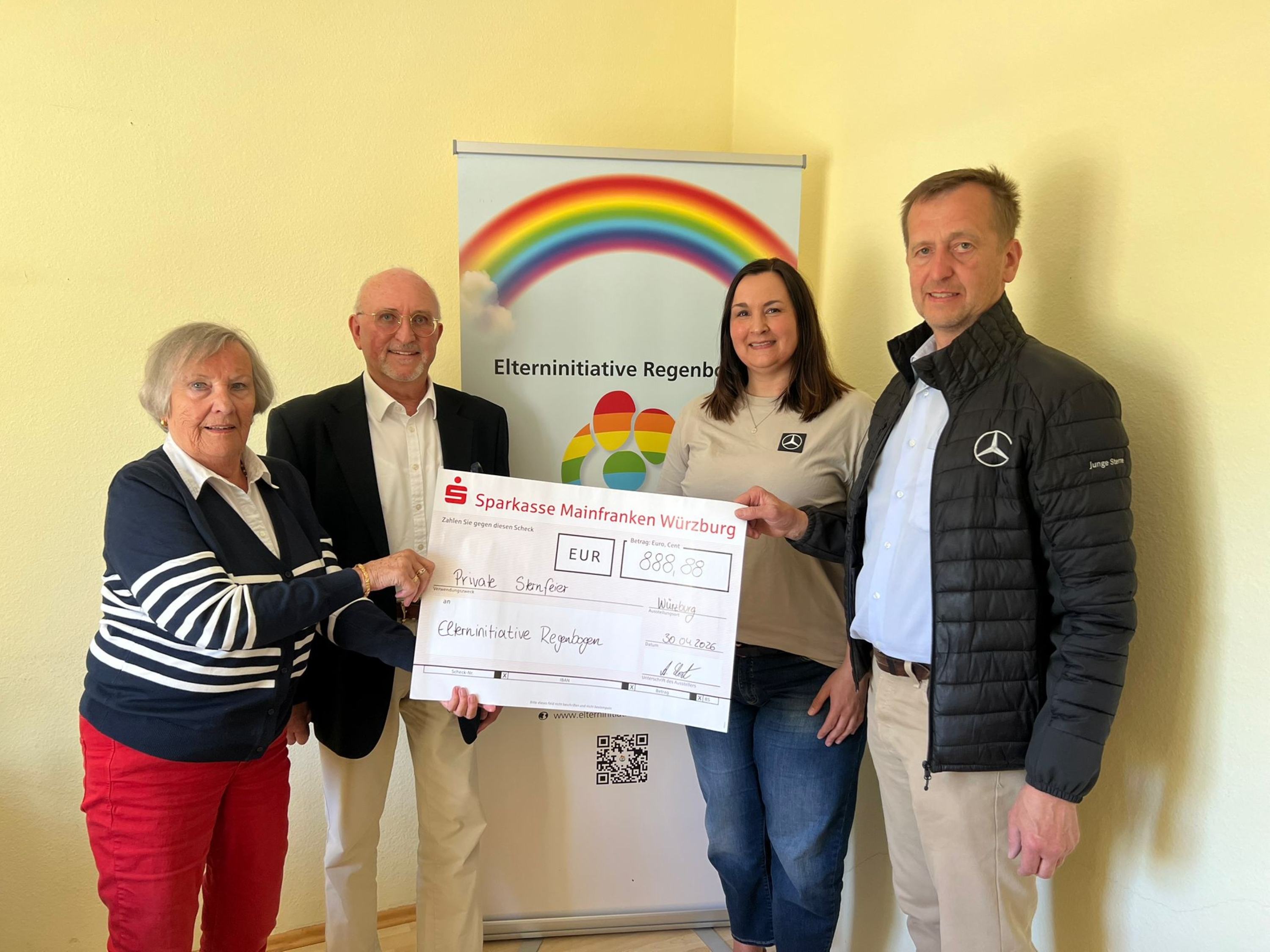 Mitarbeitende der Mercedes-Benz-Betriebe übergeben einen symbolischen Spendencheck an die Elterninitiative Regenbogen