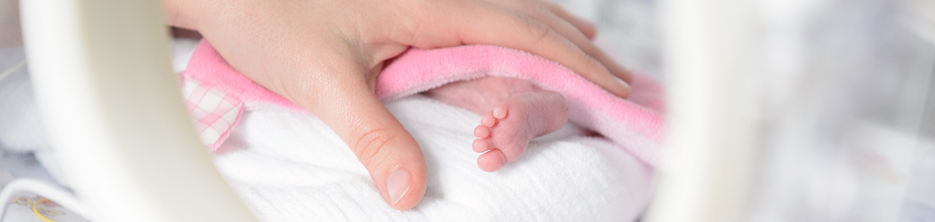 Illustrationsbild Hand mit winzigem Frühgeborenen-Fuß