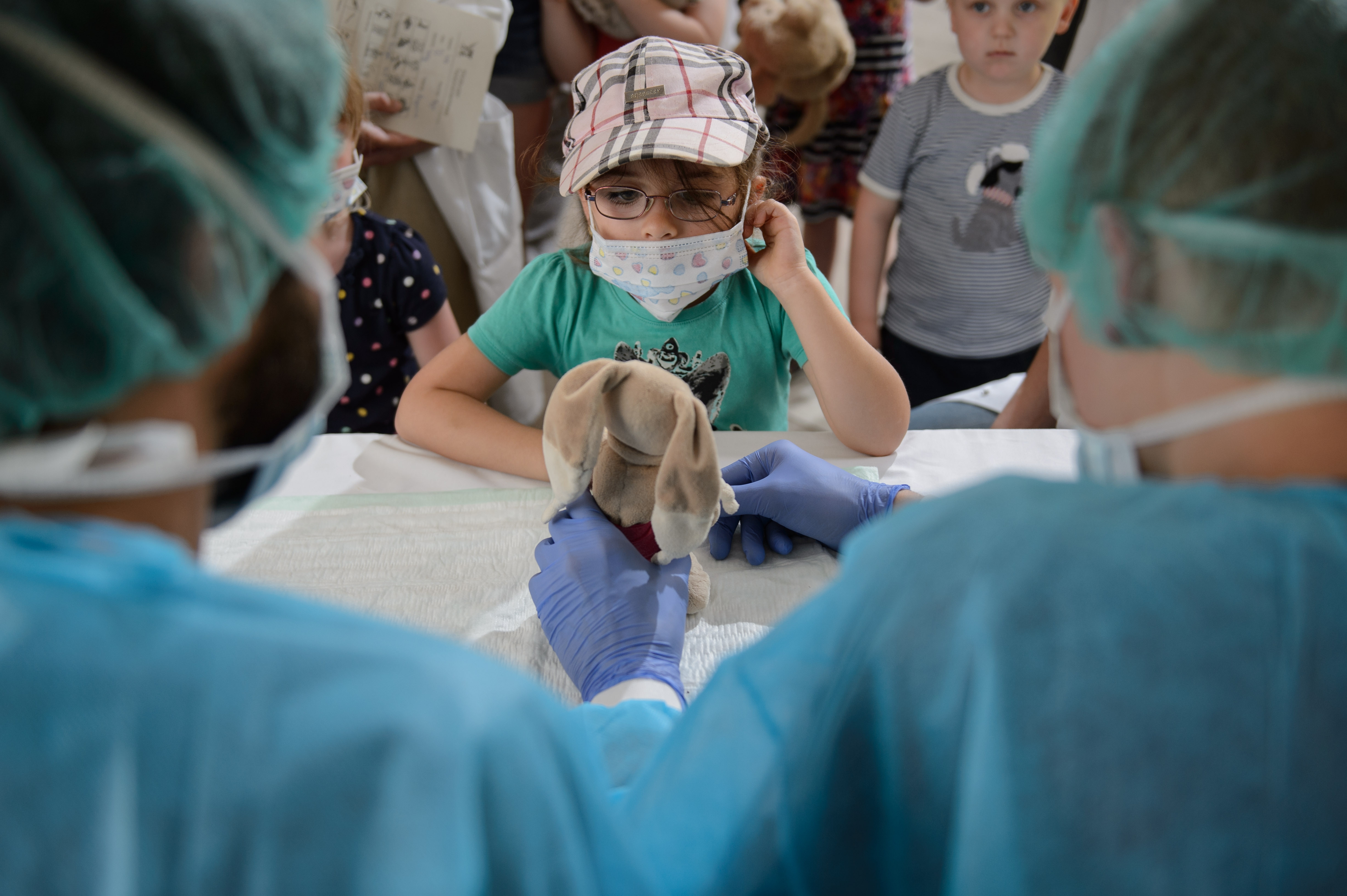 Ein Teddy wird "operiert" von Ärzten im OP-Kittel