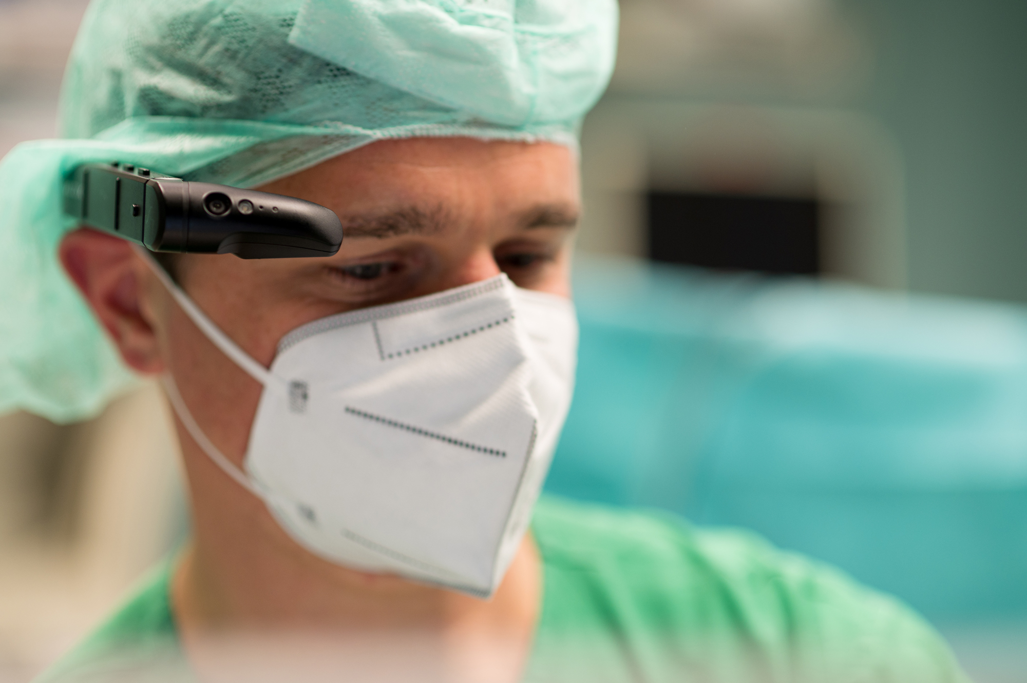 Foto zeigt Funktionsoberarzt Christoph Koch der das Head-Mounted-Display während seiner Arbeit als anästhesiologischer Supervisor im OP trägt.