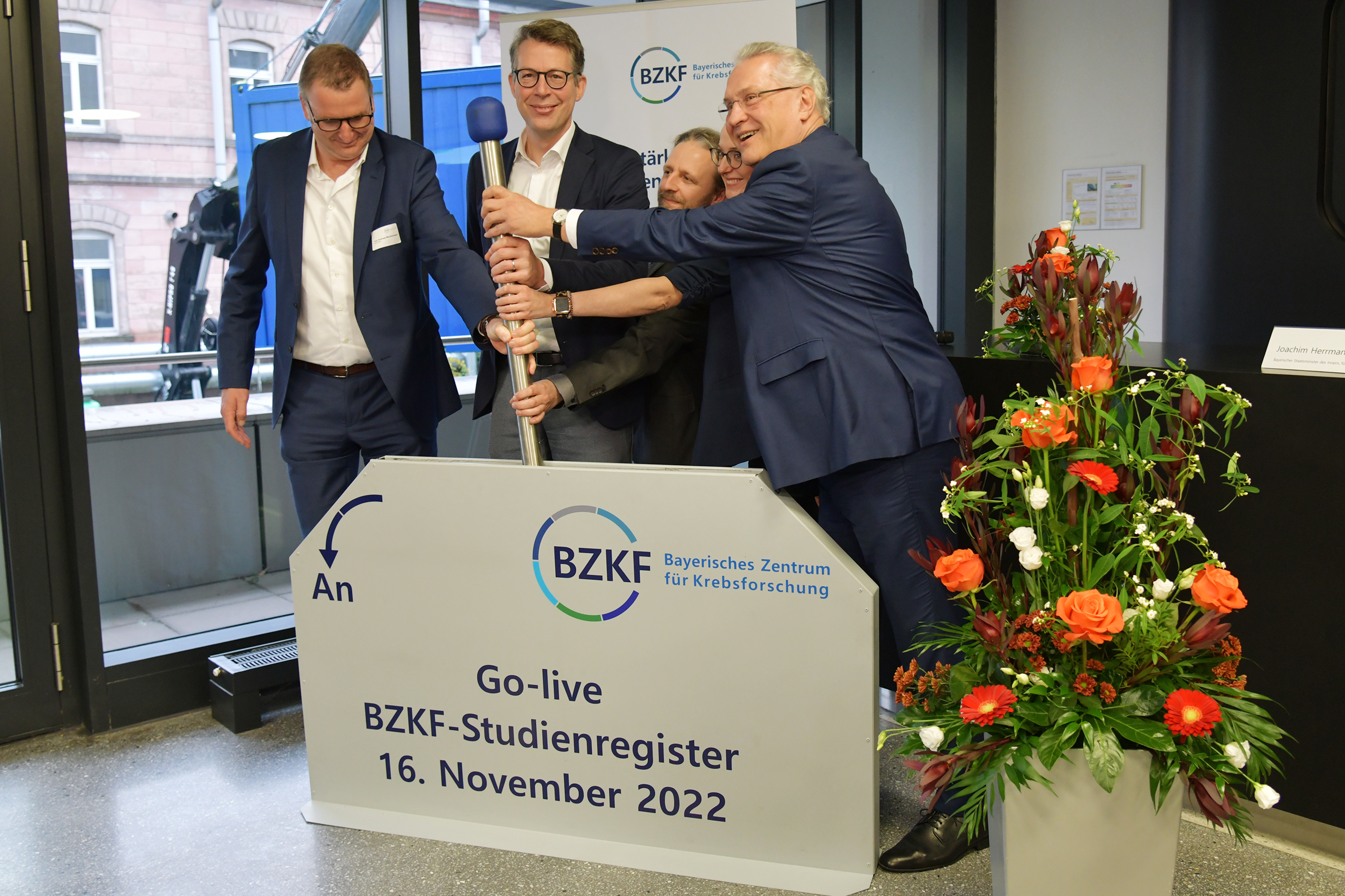 Prof. Andreas Mackensen, Direktor des BZKF, Staatsminister Markus Blume, Dr. Thomas Ramming, Susanna Zsoter, Staatsminister Joachim Herrmann (v. l.) betätigen den Hebel zur Eröffnung.