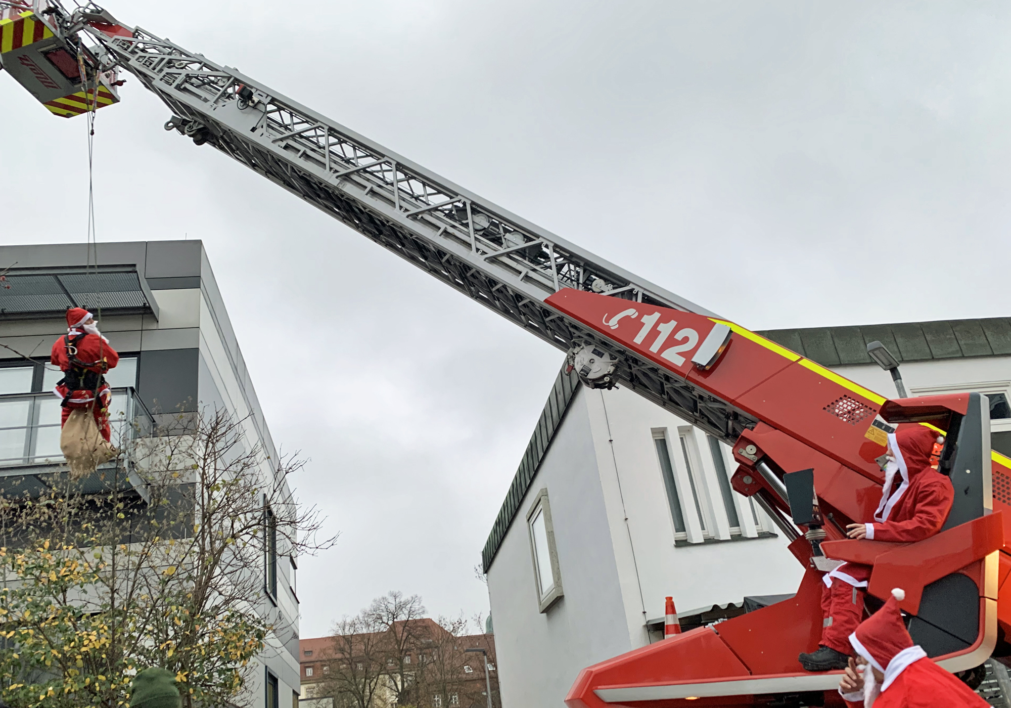 Feuerwehrmann als Nikolaus mit Drehleiter