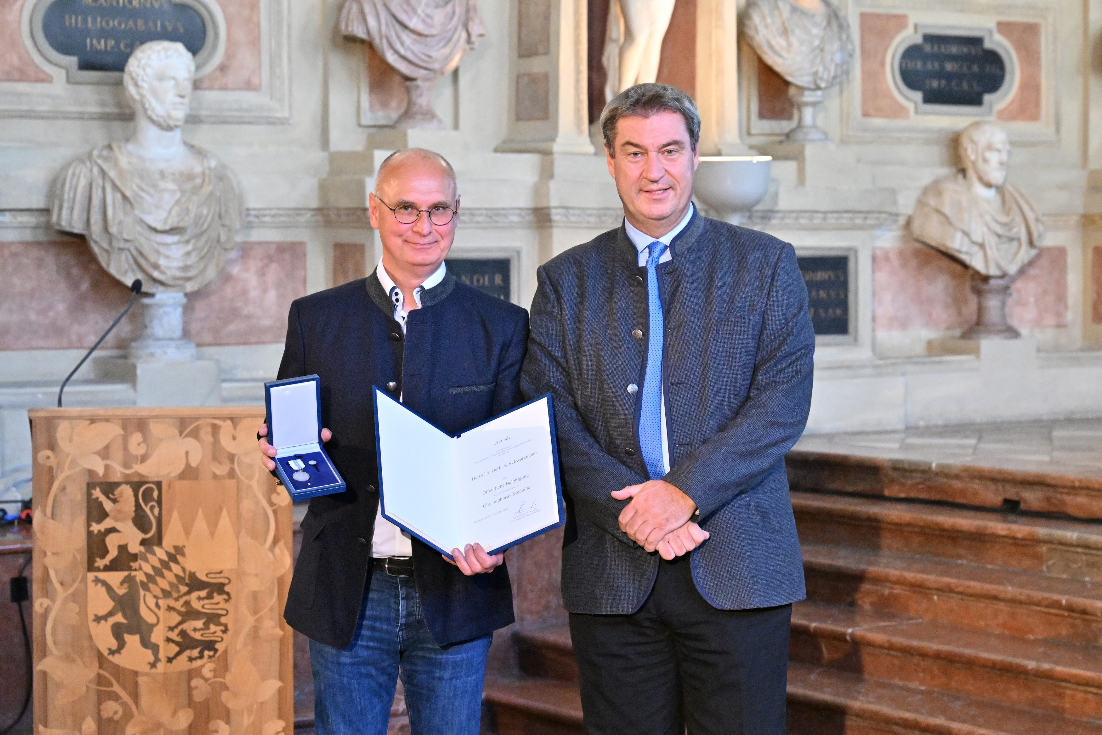 Ministerpräsident Söder und Dr. Schwarzmann mit Urkunde und Christophorus-Medaille