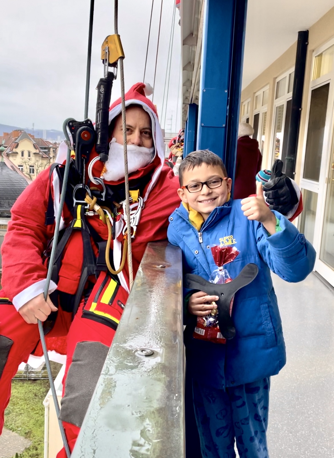 Feuerwehrmänner seilten sich an der Fassade der Kinderklinik ab. Diego (rechts im Bild) freute sich sehr über den Besuch. Foto: UKW / Kim Sammet
