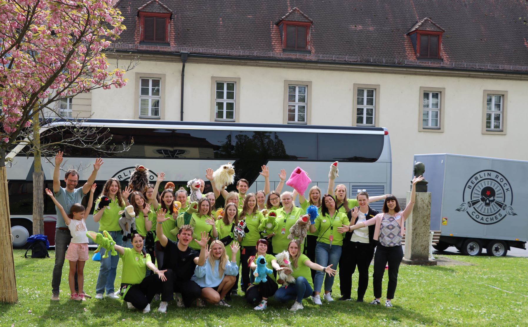 Team von Kinderklinikkonzerte e. V. und Mitarbeitende des UKW draußen auf einer Wiese des UKW