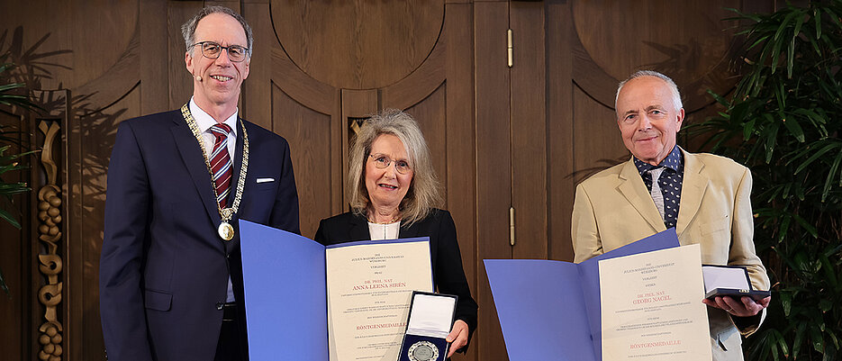 Die Röntgen-Medaillen für exzellente Forschung gingen an Professor Georg Nagel und Professorin Anna-Leena Sirén. Überreicht wurden sie von Universitätspräsident Paul Pauli. (Bild: Rudi Merkl / Universität Würzburg)