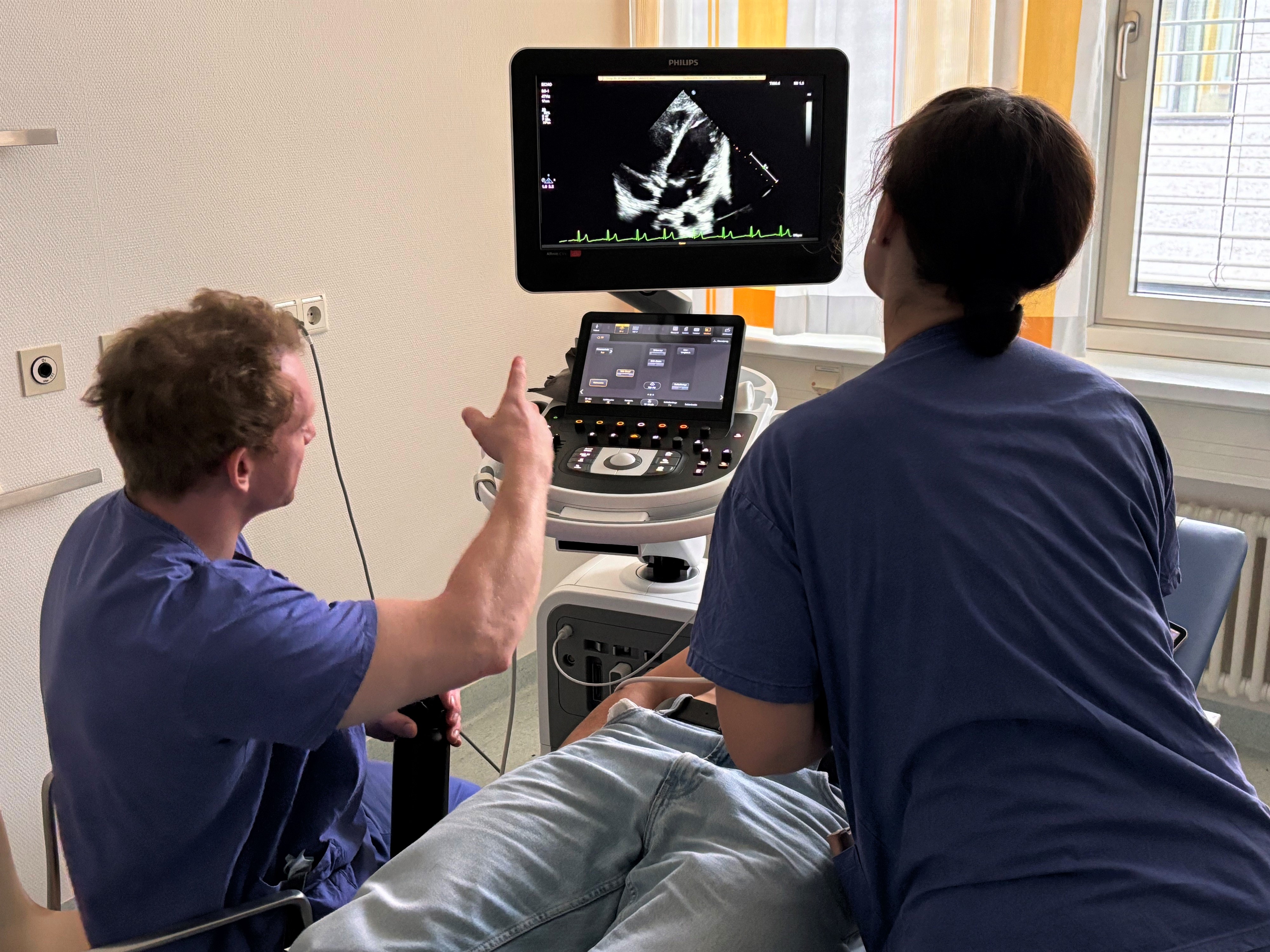 Person deutet auf Monitor für Ultraschalluntersuchungen